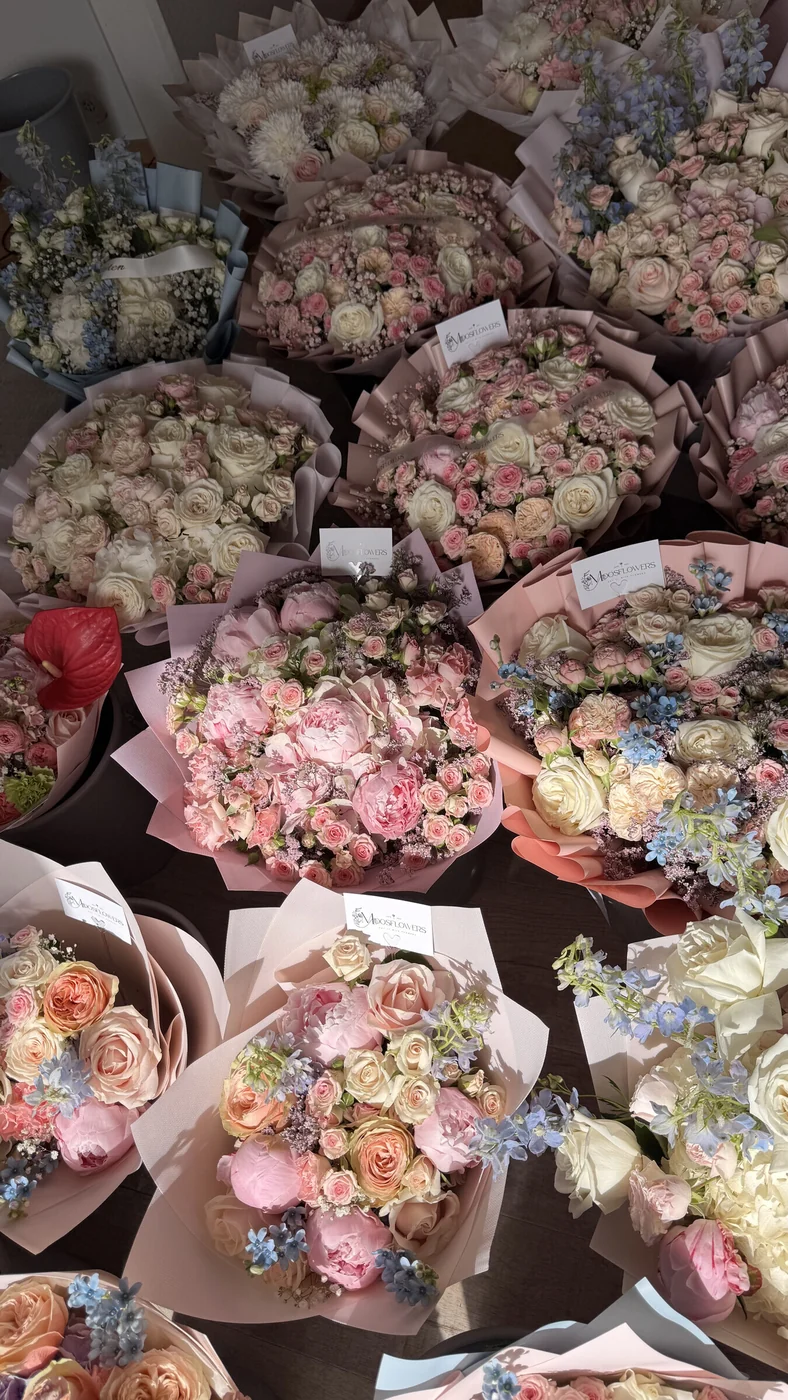 Pastellbuketter med rosor, anthurium och blå småblommor i Midosflowers blomsterateljé i Malmö